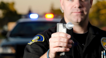 a police officer holding breath testing device