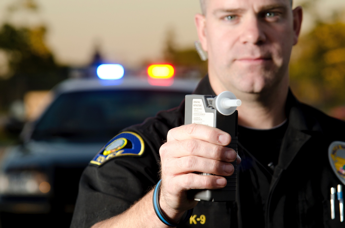 a police officer holding breath testing device