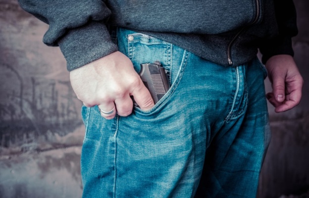 a man carrying a gun in his pocket