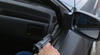 a man holding a gun in a vehicle