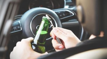 a person opening a beer in a vehicle