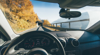 A car with ADAS cruising along a narrow road